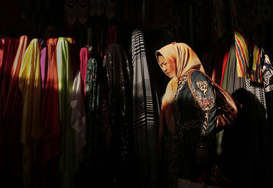 تتجول إمرأة تلبس ملابس ذات خصائص إسلامية محلية في متجر.