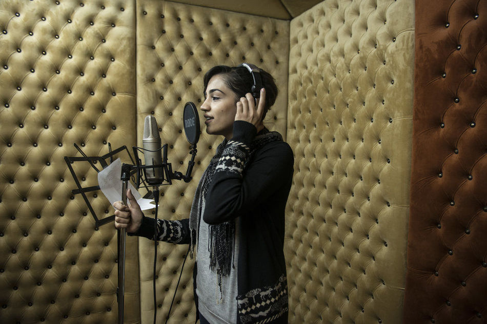 الفتاة البالغة من العمر 25 عاما تغني في أستوديو لتسجيل أغنية.   