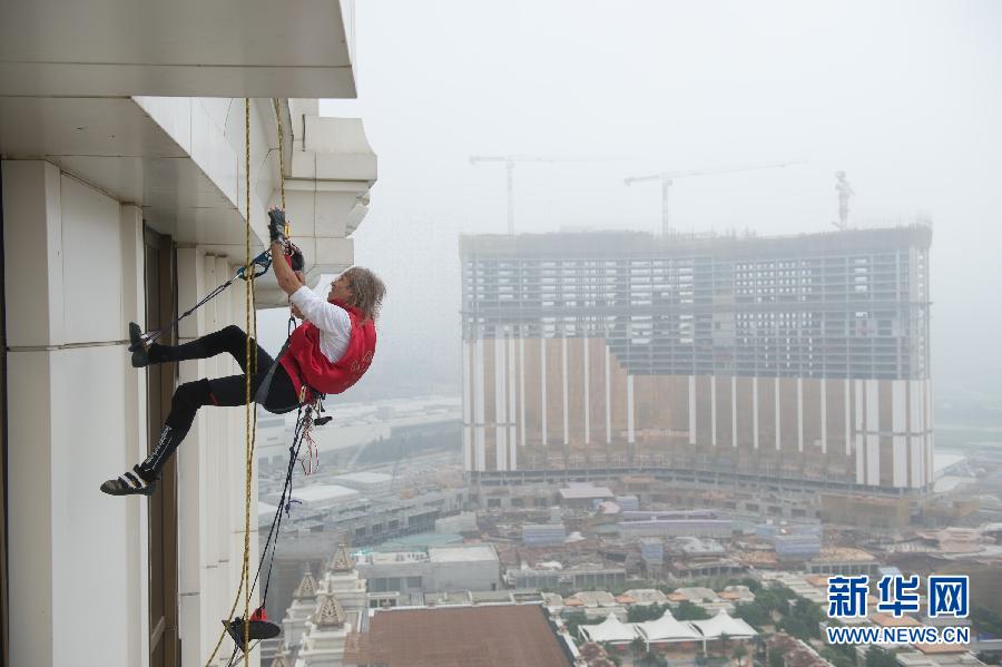 الفرنسي آلان روبرت المعروف بـ"الرجل العنكبوت" يتسلق مبنى فندق "جالاكسى ماكاو" الشهير بالصين البالغ ارتفاعه 153 مترا في 23 أبريل 2014