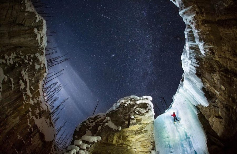 تسلق شلال متجمد في ليلة باردة بعدسة مصور