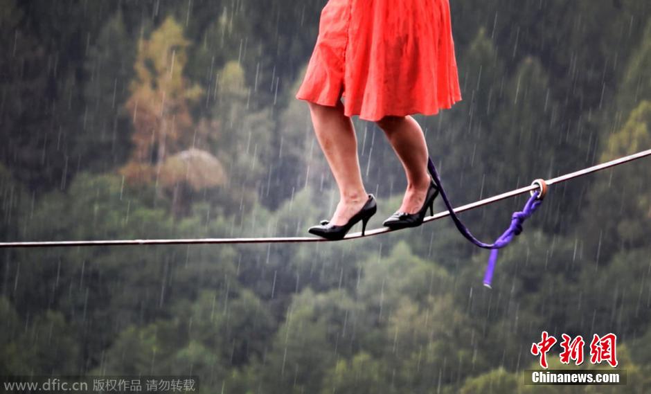 فتاة أمريكية مرتدية أحذية الكعب العالي تعرض المشي الجوي على حبل