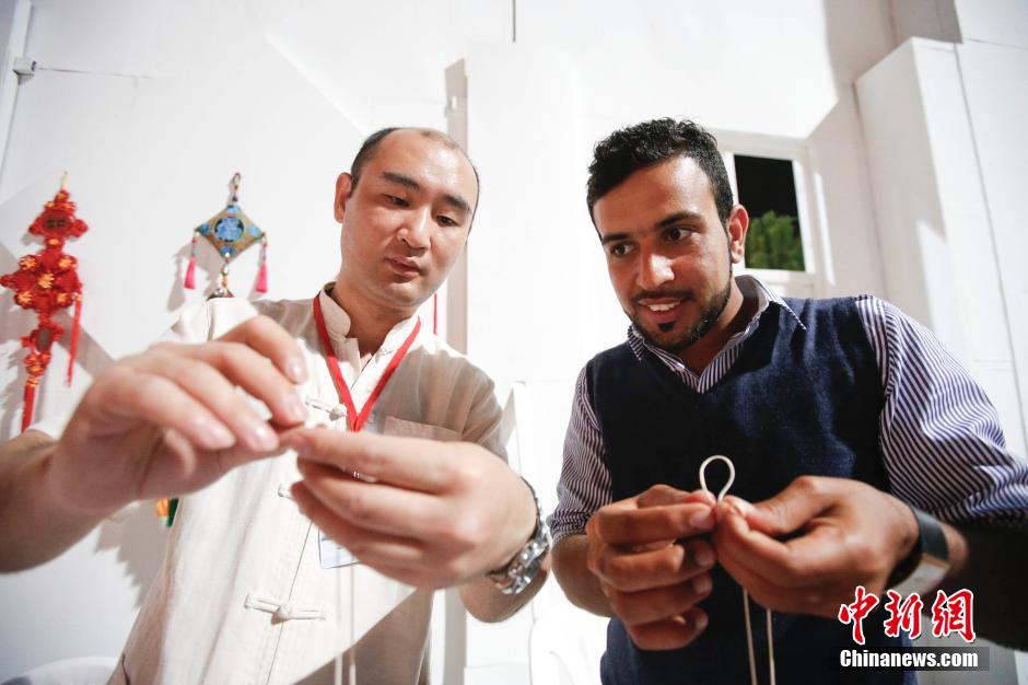 ينظم جناح الصين "دروس العقدة الصينية" خلال مهرجان مسقط الدولي للفنون لتعليم الزوار العمانيين صنع العقدة الصينية في 31 يناير. 