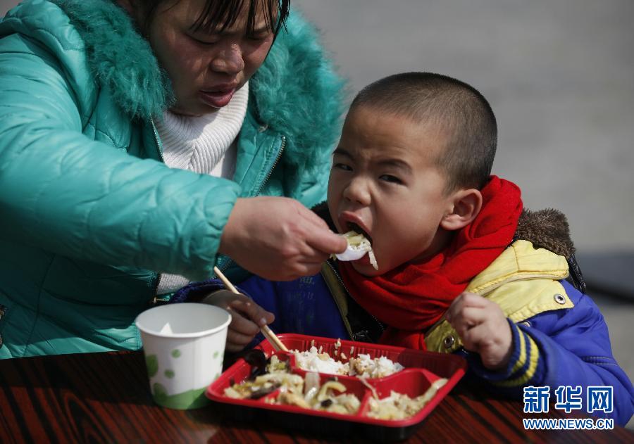 9 فبراير، مدينة لونغ يان بمقاطعة فوجيان، تشيوهاي، عمره 5 سنوات، بصدد تناول وجبة مجانية ساخنة توفرها محطة البنزين. حيث يرافق أمه في العودة من تشوانتشو إلى قانتشو الغربية لقضاء عيد الربيع.