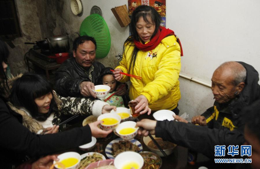  مساء 9 فبراير، مدينة روجين بجيانغشي، وانغ فولين، الثاني على اليسار، يحتضن حفيده الصغير ويتناول العشاء مع العائلة.