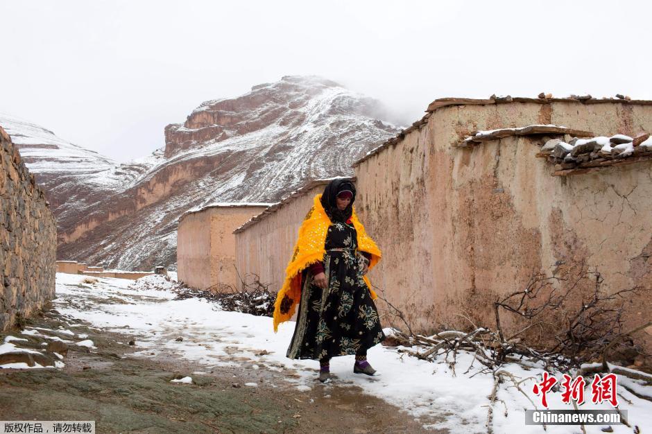 تمر إمرأة محلية بقرية Tilmi المغطية بالثلوج في جبال الأطلس العالية. 