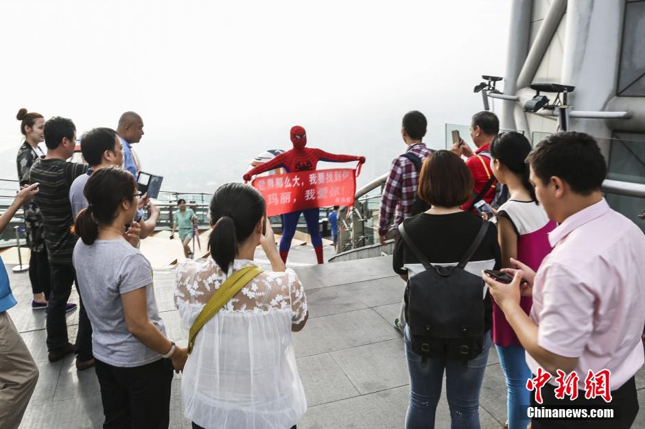 شاب صيني يتسلق برجا شاهقا فى هيئة الرجل العنكبوت لطلب يد صديقته