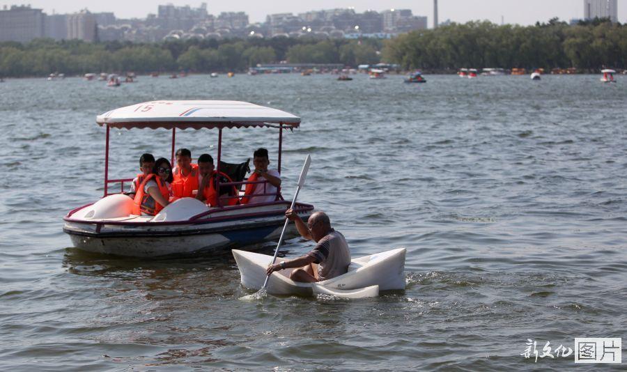 مسن من مدينة تشانغتشون يجدف بقارب صنعه من الرغوة في بحيرة نانهو