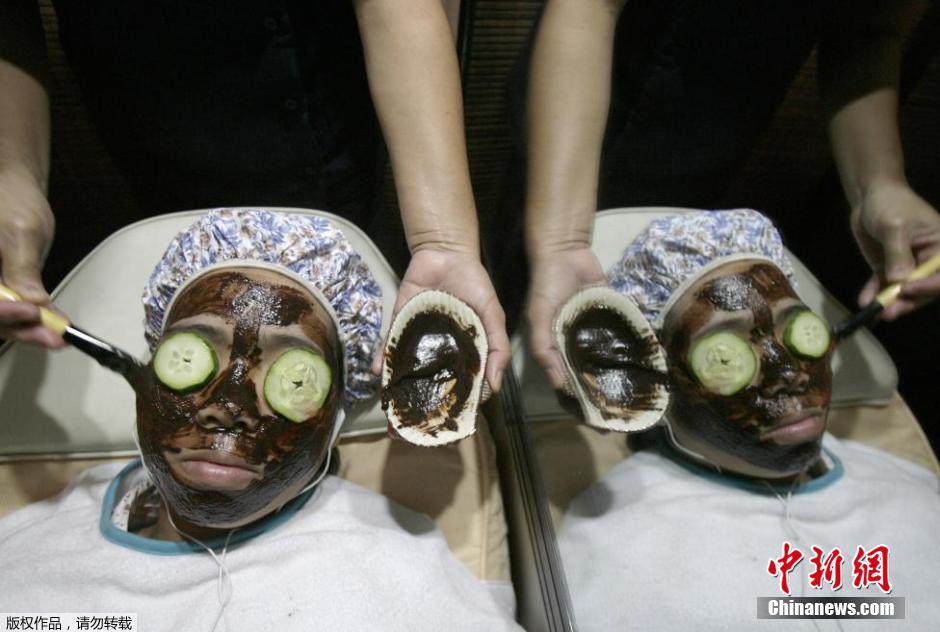 تقوم إمرأة بوضع الشوكولاته على وجهها في صالون تجميل بكويزون الفلبينية. 
