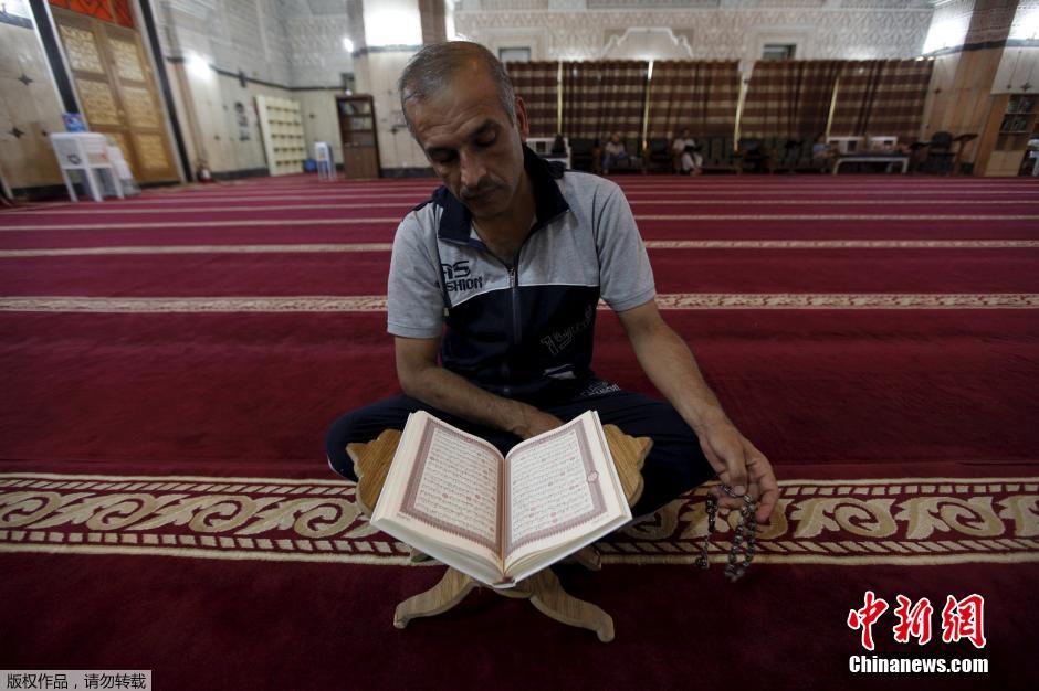 رجل يقرأ القرآن في بغداد بالعراق في 10 يوليو الجاري. 