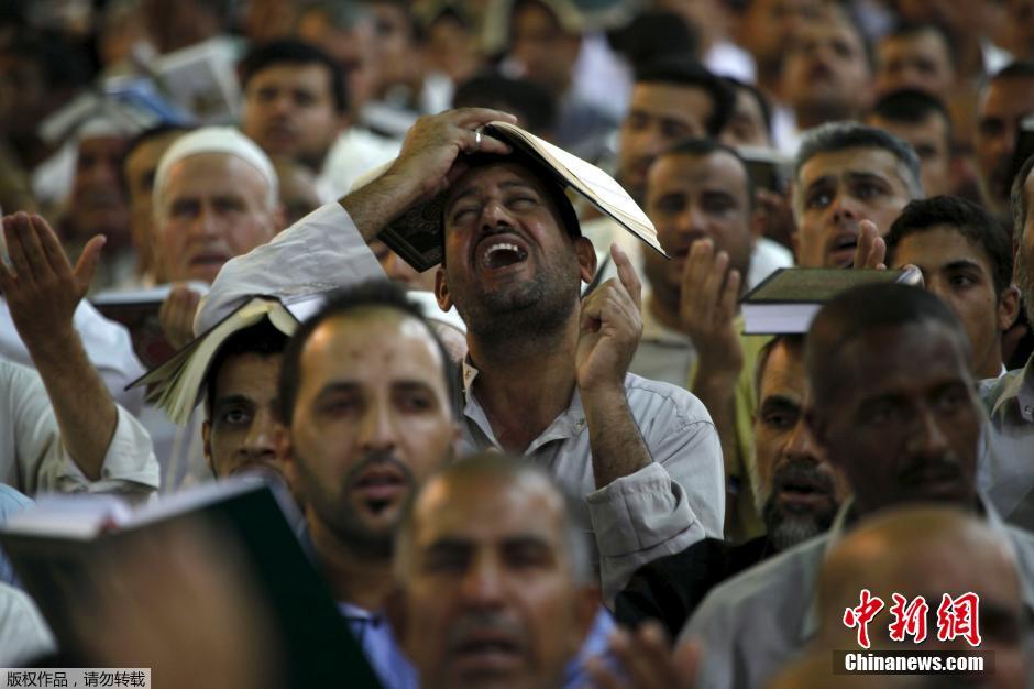 رجل شيعي يضع القرآن على رأسه في النجف بالعراق في 10 يوليو الجاري. 