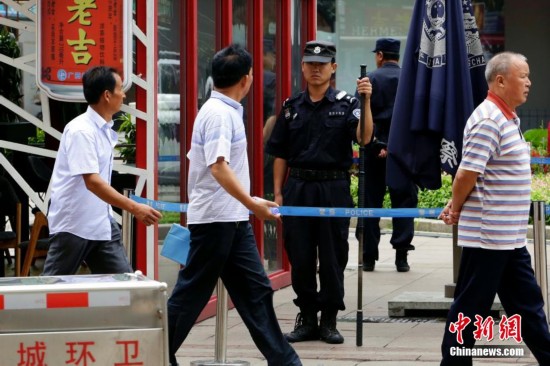 يظهر في الصورة شرطة بكين تعزز التعبئة الأمنية على شارع وانغ فو جينغ.