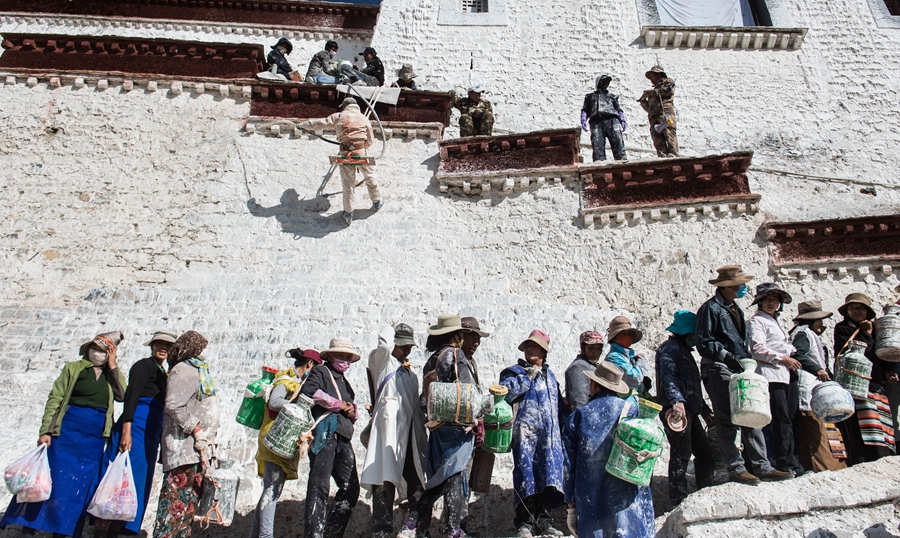 عمال يعيدون طلاء واجهة قصر بوتالا بمنطقة التبت في 21 أكتوتبر 2015