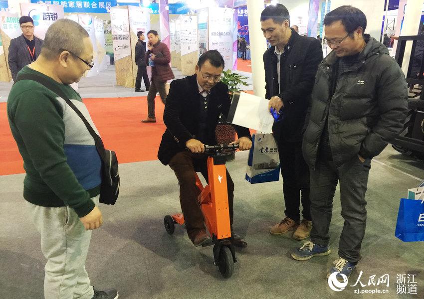 الزائر يقوم بتجربة السيارة الكهربائية قابلة للطي في معرض إيوو الصيني الدولي لتصنيع المعدات لعام 2015.