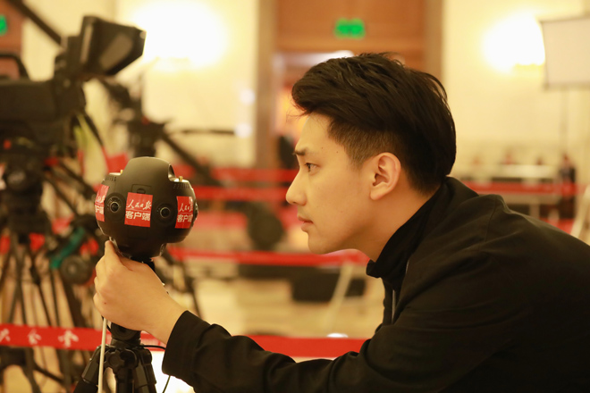 الصحفي وانغ جينغ يوان من صحيفة الشعب اليومية يختبر الكاميرا البانورامية. 