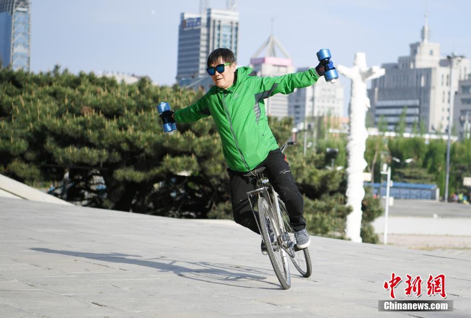رجل صيني عمره 59 عاما يعرض حركات بهلوانية على الدراجة