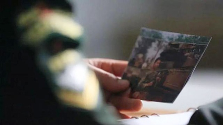 جندي سيشارك في العرض العسكري برفقة صورة رفيقه الشهيد