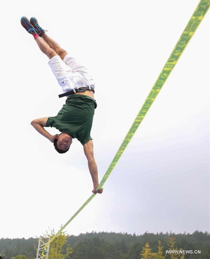 شاب يمشي على شريط مسطح على ارتفاع شاهق في الصين