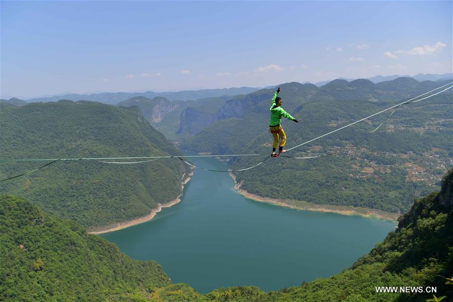 شاب يمشي على شريط مسطح على ارتفاع شاهق في الصين