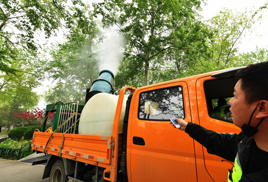 شاحنات لرش المياه للتخلص من وبر الصفصاف في مدينة بكين