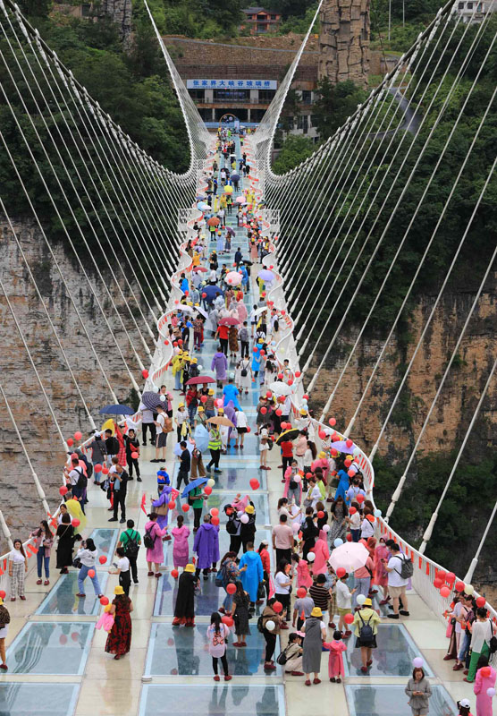 تشانغجياجيه، هونان: السياح يتجولون عبر الجسر الزجاجي