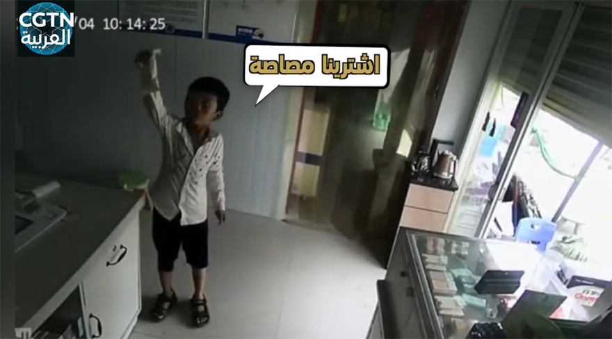 صبيان يظهران الأشياء المراد شراؤها والنقود لكاميرا المراقبة أثناء غياب صاحب المحل