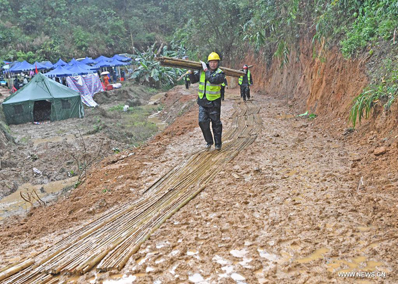 رجال الإنقاذ يزيلون حطام الانهيارات الأرضية الناجمة عن الأمطار في موقع تحطم الطائرة