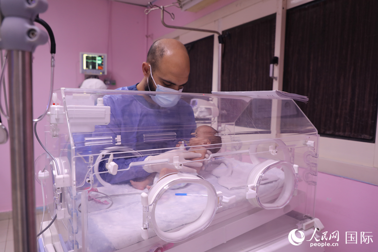 طبيب في مستشفى العريش يعالج الطفل المبتسر القادم من قطاع غزة. الصورة/ شين شياو شياو، صحيفة الشعب اليومية أونلاين