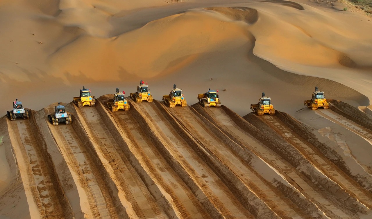 مذهل: مئات الجرافات تدفع الرمال لتسوية الأرض في صحراء كوبوتشي