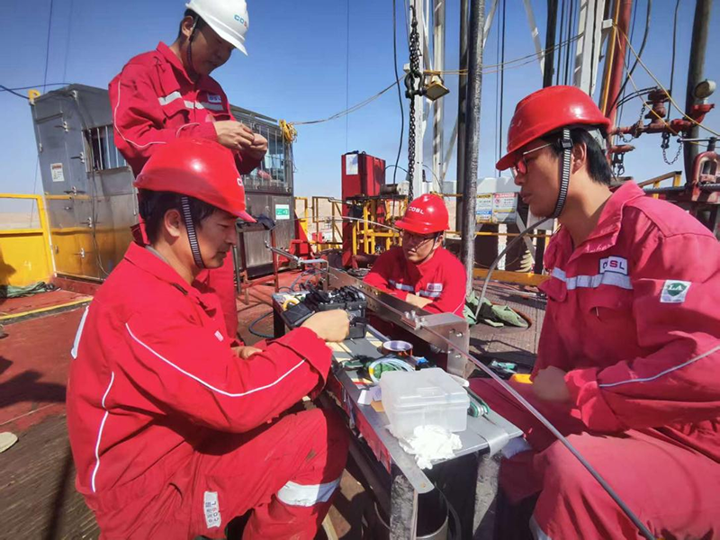 العمال يقومون بتركيب كابلات الألياف الضوئية. الصورة/ شركة CNOOC العراق المحدودة