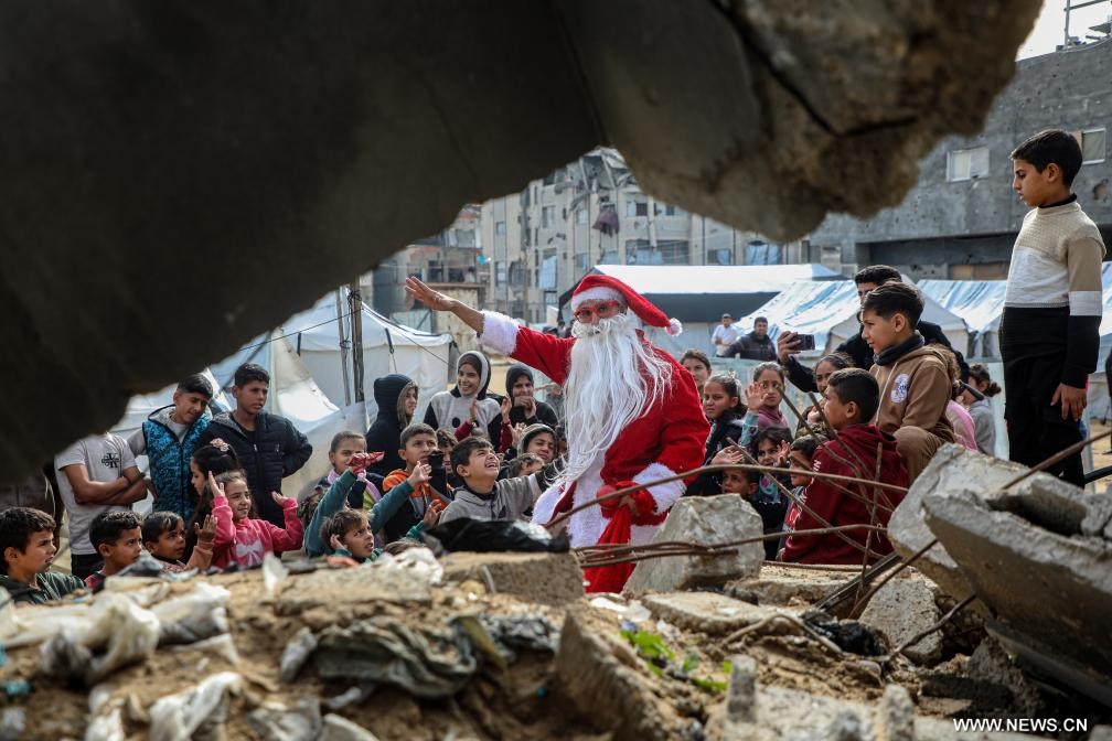 فلسطيني في زي بابا نويل يوزع الحلوى في مدينة غزة