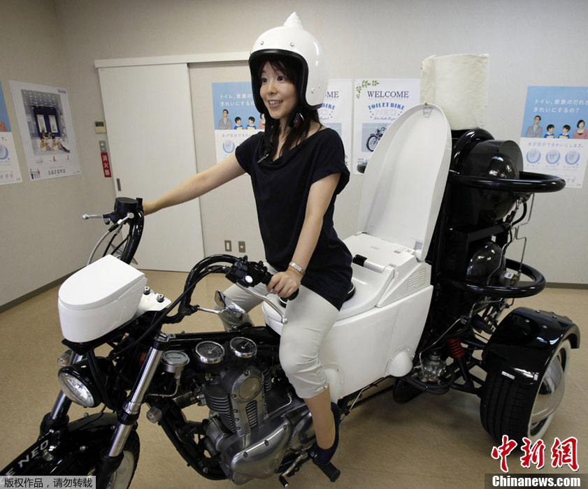 عارضة يابانية تقدم دراجة نارية مزودة بمرحاض تعمل بفضلات الإنسان والمواشي والمياه المهملة بمدينة فوجيساوا اليابانية في 23 أغسطس 2012