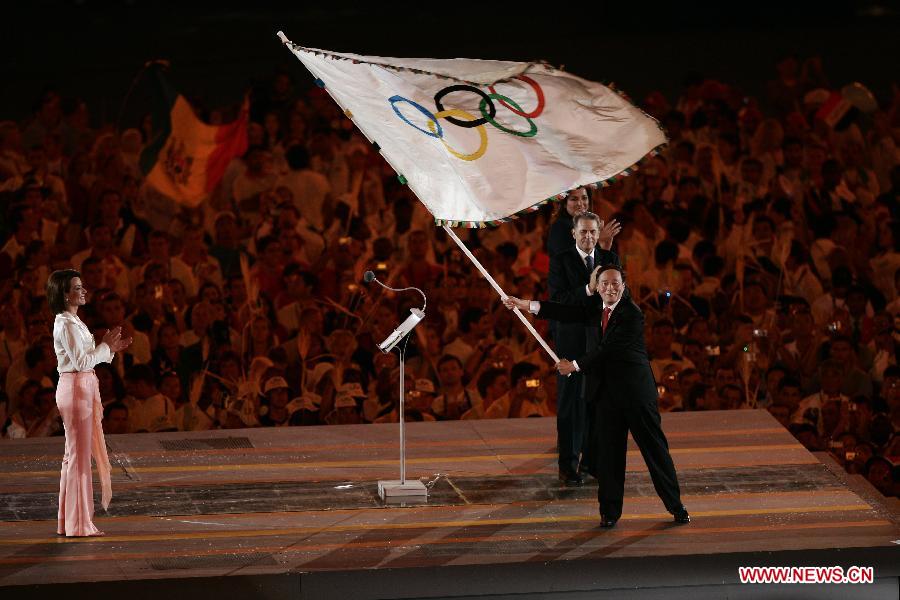 بكين 25 ديسمبر 2012/في الصورة الملتقطة يوم 30 أغسطس 2004، وانغ تشي شان يرفع علم الأولمبياد خلال مراسم اختتام أولمبياد أثينا.