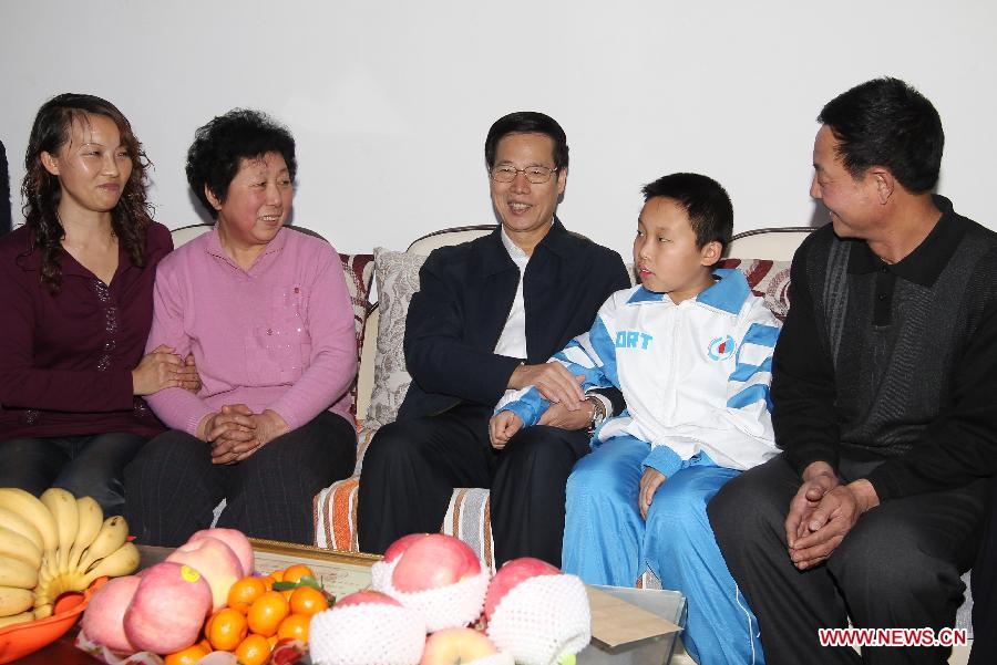 بكين 25 ديسمبر 2012/في الصورة الملتقطة يوم 16 يناير عام 2012، تشانغ قاو لي (في الوسط) يزور أسرة فقيرة بحي بيتشن ببلدية تيانجين قبل عيد الربيع الصيني.