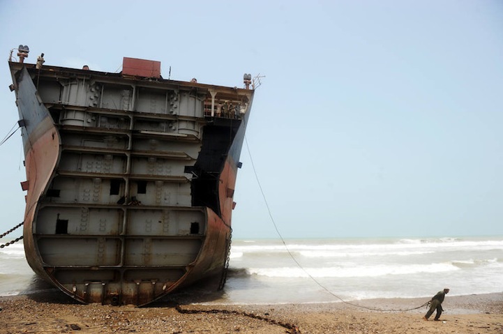 عامل يفكك سفينة قديمة متروكة في 10 يوليو 2012