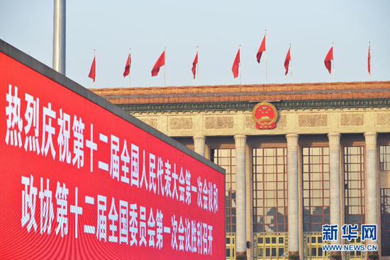 الشعار لاحتفال بعقد دورتي عام 2013 أمام قاعة الشعب الكبري في بكين