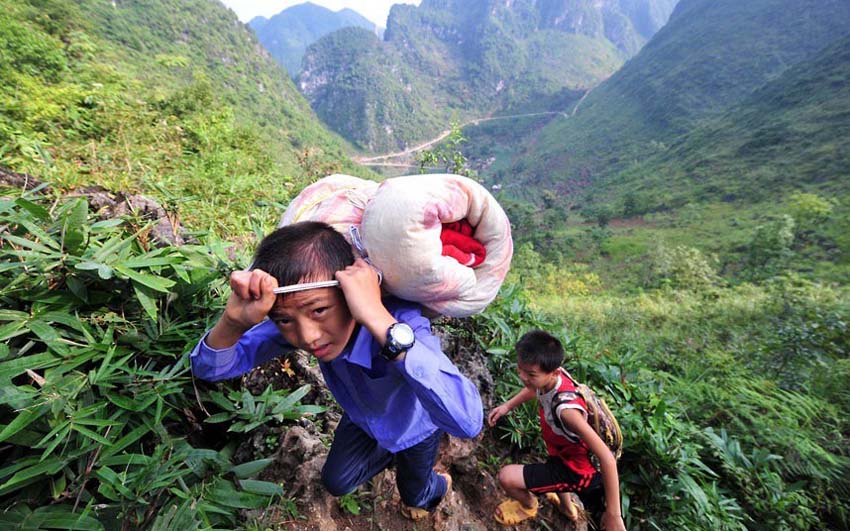تلميذان يتسلقان الجبال الوعرة إلى المدرسة في محافظة داهوا لقومية ياو في مقاطعة قوانغشي.