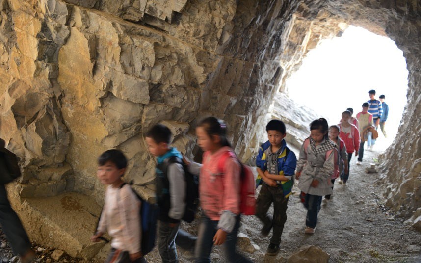 يذهب الأطفال إلى إحدى المدارس التي تقع في سفح التل في طريق جبلي ضيق بمنطقة بيجيه بمقاطعة قويتشو الصينية.   