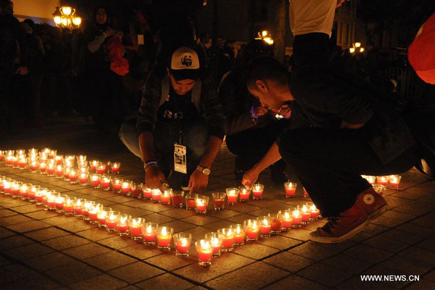 في الصورة الملتقطة يوم 23 مارس 2013، تونسيون يضيئون الشموع خلال مشاركتهم في فعاليات "ساعة الأرض" في شارع الحبيب بورقيبة بالعاصمة التونسية. أعطت سيدني مساء يوم السبت شارة الإنطلاق لحملة "ساعة الأرض"، التي يتم فيها إطفاء الأنوار في أبرز المعالم والمباني حول العالم لساعة واحدة بهدف التوعية من مخاطر التغير المناخي وذلك للسنة السابعة على التوالي، وعند الساعة 20.30 بالتوقيت المحلي لكل بلد يتم إطفاء الأنوار في أكثر من 150 بلدا، إحياءا لأضخم الفعاليات البيئية في العالم. (شينخوا / عادل الزين)