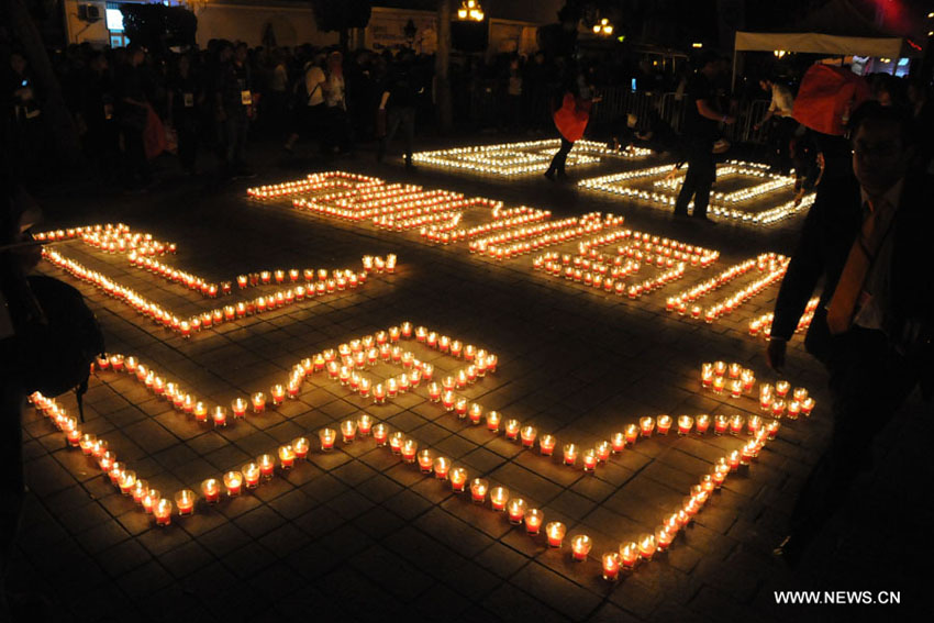 في الصورة الملتقطة يوم 23 مارس 2013، تونسيون يتجمعون حول الشموع خلال مشاركتهم في فعاليات "ساعة الأرض" في شارع الحبيب بورقيبة بالعاصمة التونسية. أعطت سيدني مساء يوم السبت شارة الإنطلاق لحملة "ساعة الأرض"، التي يتم فيها إطفاء الأنوار في أبرز المعالم والمباني حول العالم لساعة واحدة بهدف التوعية من مخاطر التغير المناخي وذلك للسنة السابعة على التوالي، وعند الساعة 20.30 بالتوقيت المحلي لكل بلد يتم إطفاء الأنوار في أكثر من 150 بلدا، إحياءا لأضخم الفعاليات البيئية في العالم. (شينخوا / عادل الزين)