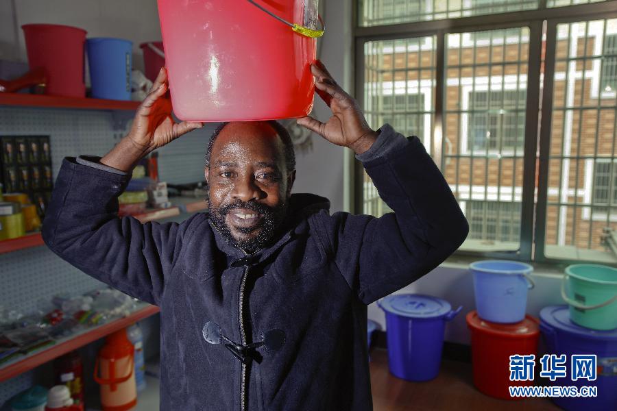 التاجر كاكول، التاجر الذي جاء من الكونغو قبل سنة يعرض كيفية استخدام الدلو في موطنه في يوم 21 مارس الجاري، وقال إن الدلاء البلاستيكية أكثر منتجاته مبيعا في موطنه.