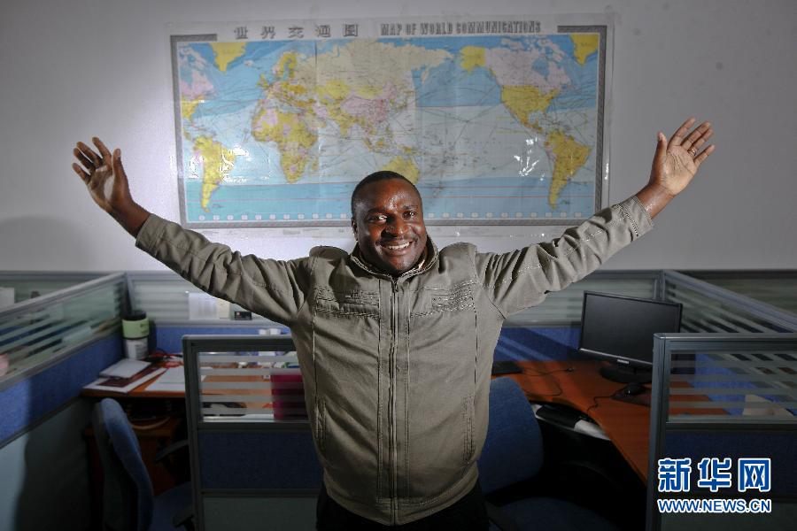 التاجر ياقبو، الذي جاء من تنزانيا إلى ييوو قبل 7 سنوات يقف أمام خريطة العالم بمكتب شريكه التجاري الصيني في يوم 21 مارس الجاري.  