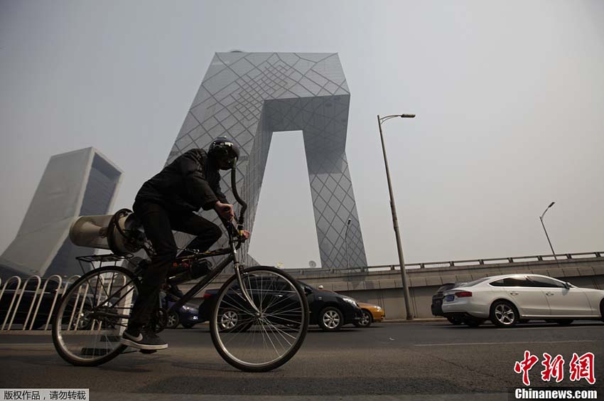 فنان أجنبي يمتطي "دراجة تصفية الهواء" في شوارع ببكين 