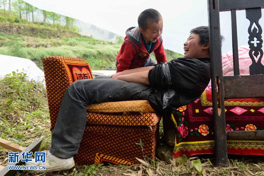 تشانغ تشي جيون يلعب مع أخوه في خيمة ببلدة تايبينغ التابعة لمقاطعة سيتشوان بجنوب غرب الصين في 21 أبريل الجاري