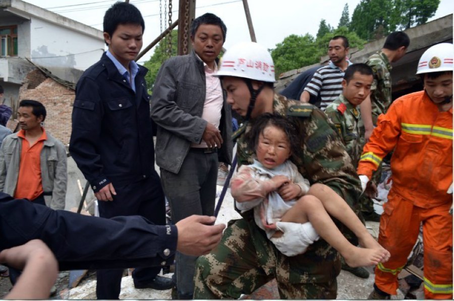 أعضاء من فريق الإطفاء والإنقاذ بمدينة ياآن في سيتشوان ينقذون طفلة صغيرة من أنقاض المنطقة التي دمرها الزلزال بمحافظة لوشان في 20 إبريل الجاري.