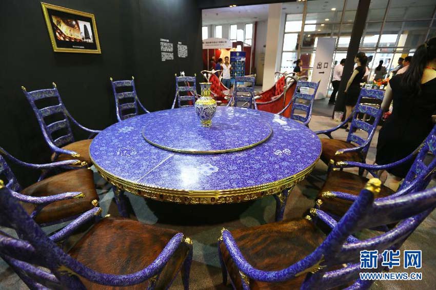 تظهر في هذه الصورة المائدة والكراسي المصنوعة من الفن الصيني التقليدي المينا المعروضة في معرض بكين الدولي للعلامات التجارية الفاخرة لعام 2013 في يوم 22 يونيو الحالي.  