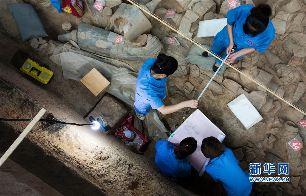 يقوم العمال بالقياس والرسم في موقع الحفر من رقم 1 لمتحف ضريح تشين شي هوانغ في يوم 18 يوليو الجاري، حيث قد تم ترقيم القطع المحطمة من التماثيل الصلصالية المكتشفة لانتظار المزيد من التنظيف والحفر.    