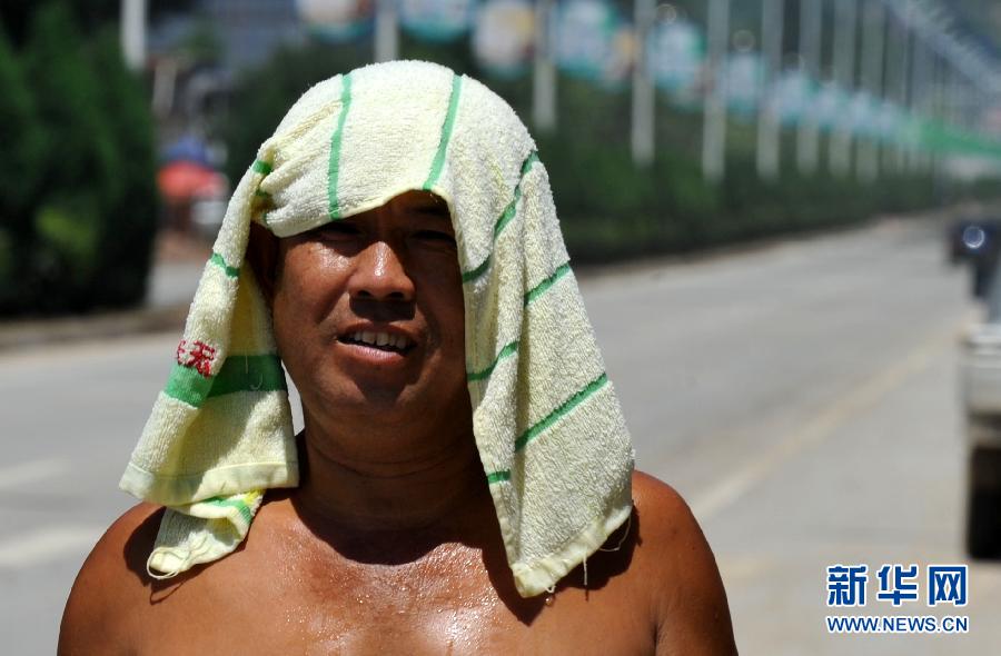 احد سكان مدينة باو دينغ بمقاطعة هبي يستعمل منشفة مبللة  لتخفيض درجة الحرارة في يوم 28 يوليو.