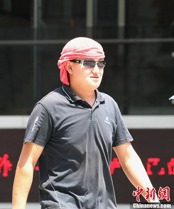 فى الصور الملتقطة يوم 5 أغسطس الحالي فى مدينة تشونغتشينغ جنوب غربي الصين، مارة يلبسون ملابس خفيفة ويرتدون النظارات الشمسية وغيرها من أدوات الوقاية من الشمس.
