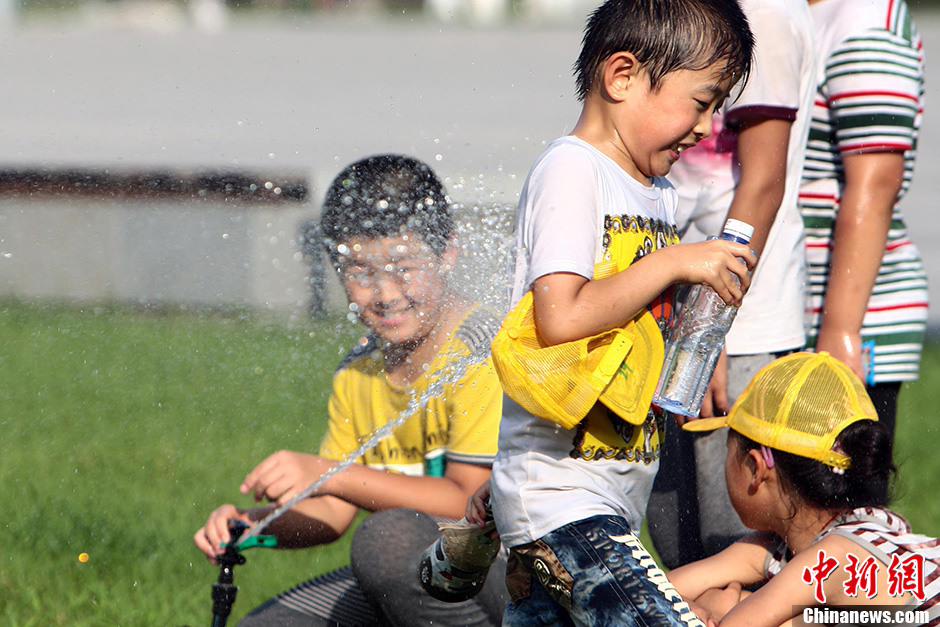 فى الصور ملتقطة مساء يوم 4 أغسطس الحالي فى مدينة تاييوان حاضرة مقاطعة شانشى  شمالي الصين، مجموعة من الأطفال  يلعبون على العشب ويتبردون بالمياه.