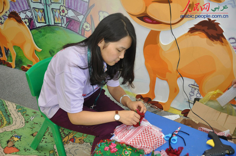 سوسن، طالبة صينية تدرس  اللغة العربية تقدم خدمات تطوعية فى  معرض بكين الدولي للكتاب